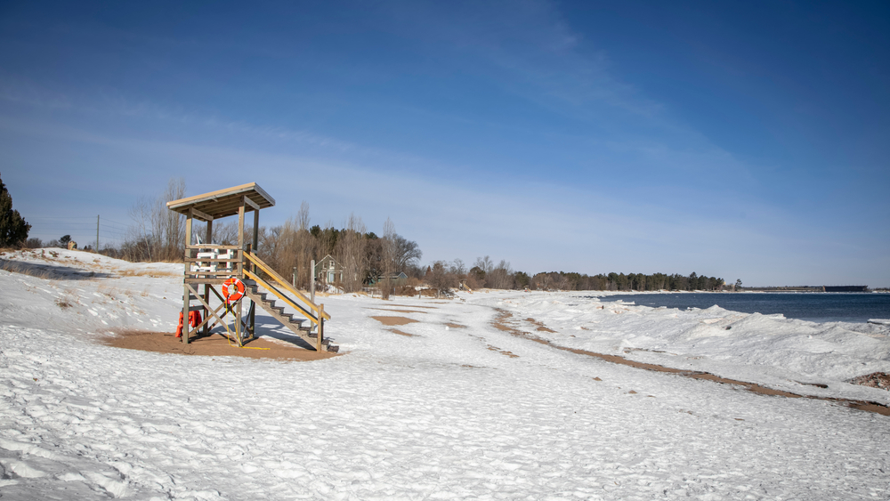 A lifeguard tower in the beach which is covered in snow in an article about things to do in Marquette MI