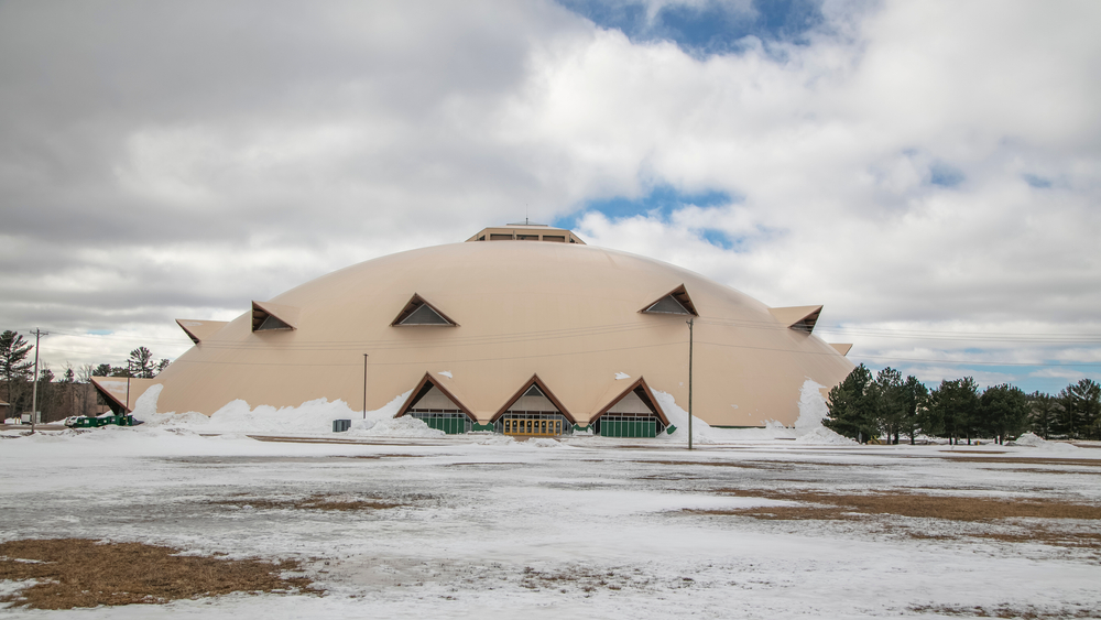A large wooden dome on a field that is covered in snow in an article about things to do in Marquette MI