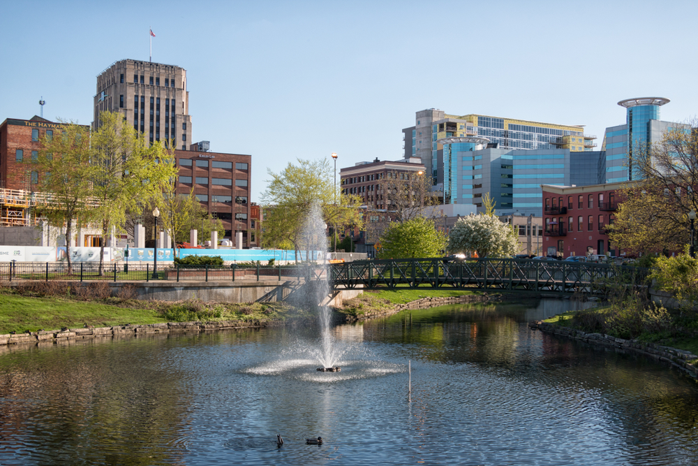 View if Kalamazoo with a fountain in the foreground and a bridge and buildings in the background