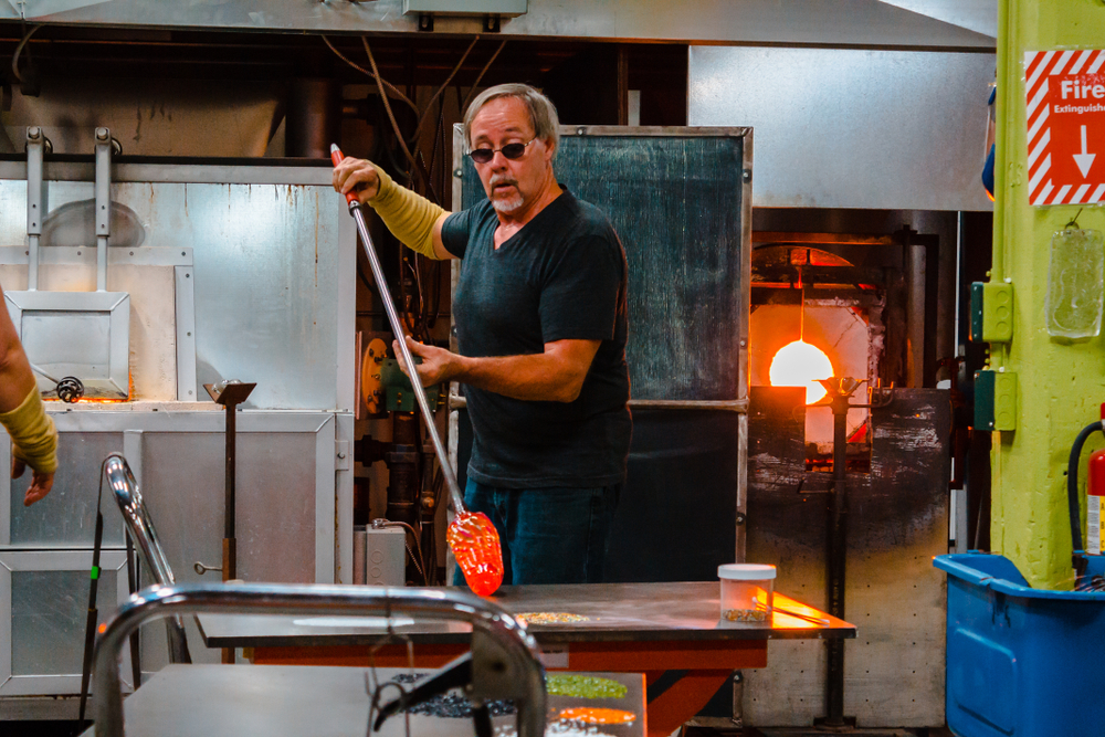 A picture of a man blowing glass in an article about things to do in kalamazoo