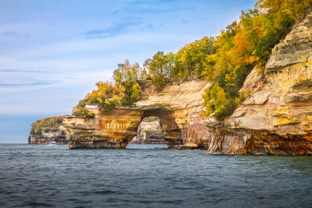 An arched rock going into the water at Pictured Rocks National Lakeshore.one of the ultimate places to visit in MI.