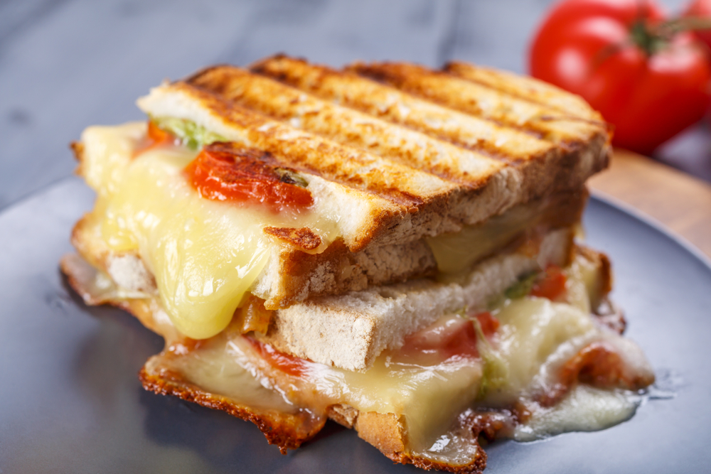 A loaded grilled cheese sandwich with tomatoes