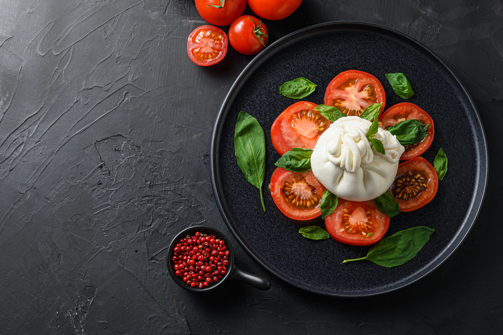 cream on tomatoes served in a black pan