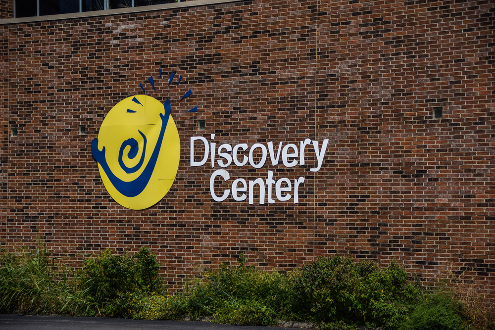 The outside of The Discovery Centre a brick wall and the logo