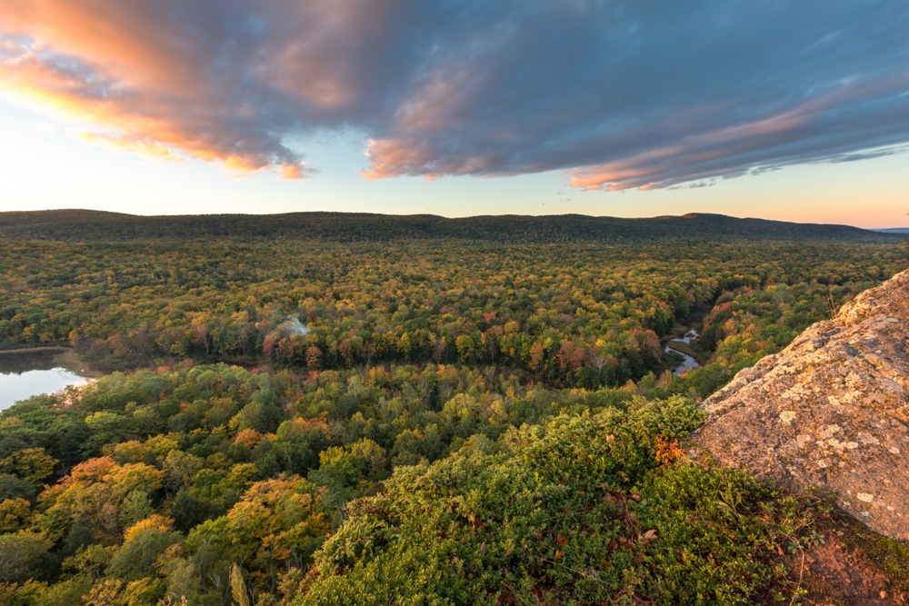 Sunset over the Porcupine Mountains Wilderness State Park with a river running through.
