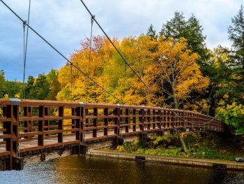 scenic trail with wooden bridge spanning river good for hiking in Michigan