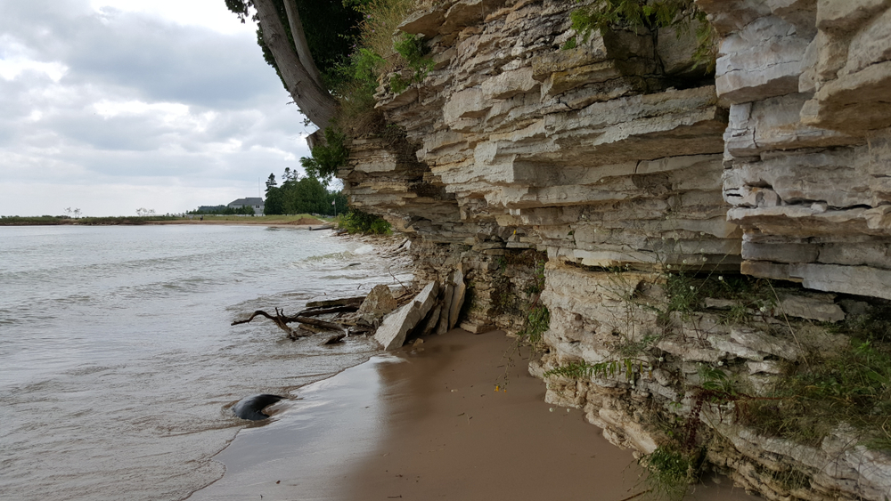 Beach with rock ridges above and the water lapping on the beach 