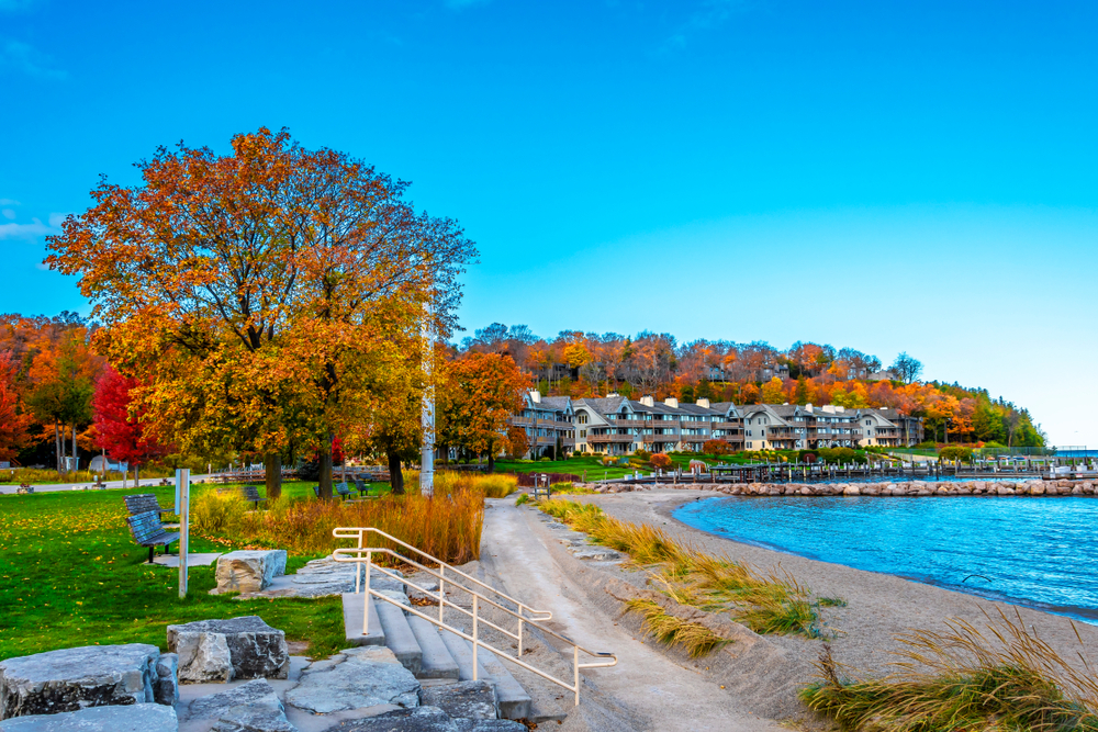 The beautiful Sister Bay with the steps to the beach in the foreground and buildings and trees in the background 