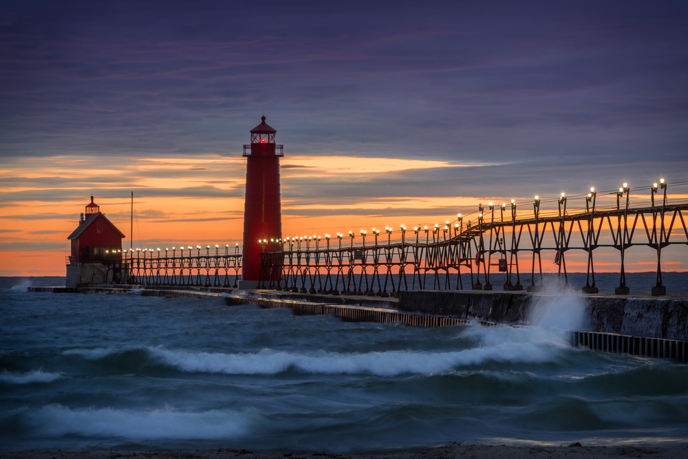 A long concrete pier with lights on it and two red lighthouses. You can find them at one of the best state parks in Michigan. 