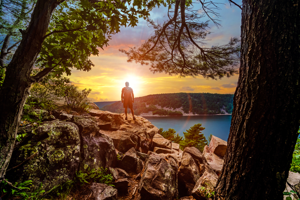 Walker stood on rock looking out over  a lake view in an article about hiking in Wisconsin 