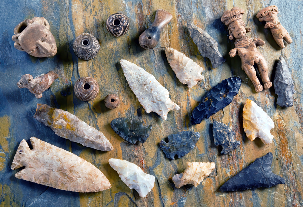 A collection of Native American artifacts like arrow heads, beads, and figurines, similar to what you'd find at the Mid-America All-Indian Museum in Wichita Kansas. 