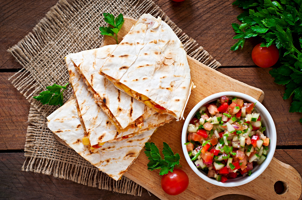 Quesedillas on a wooden borad with a side salsa in an article about restuarants in Mackinac Island