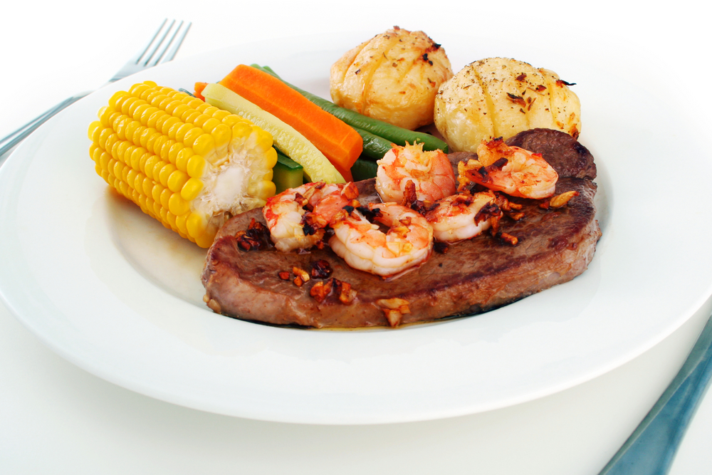Surf and turf on a plate with potaotes and sweetcorn 