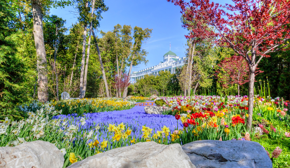 A beautiful garden of colorful flowers and trees that leads up to the Grand Hotel on Mackinac Island.