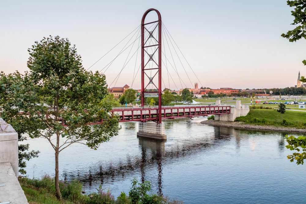 A red bridge stretching over the river on the Riverwalk in Mishawaka, Indiana.