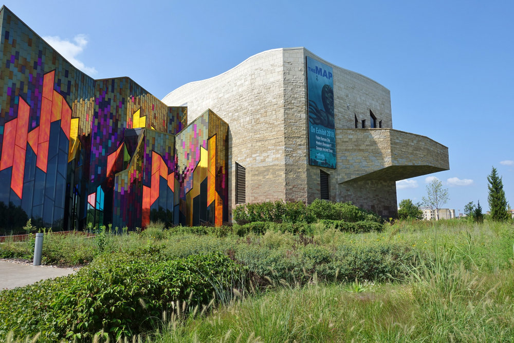 Exterior of the Museum at Prairiefire with a grassy area in front and the colorful glass shining.