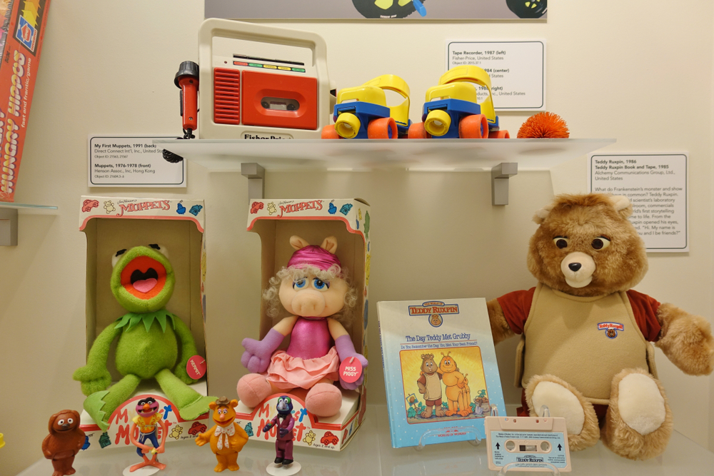 Shelves at the National Museum of Toys and Miniatures with an assortment of Muppets and Fisher Price toys.