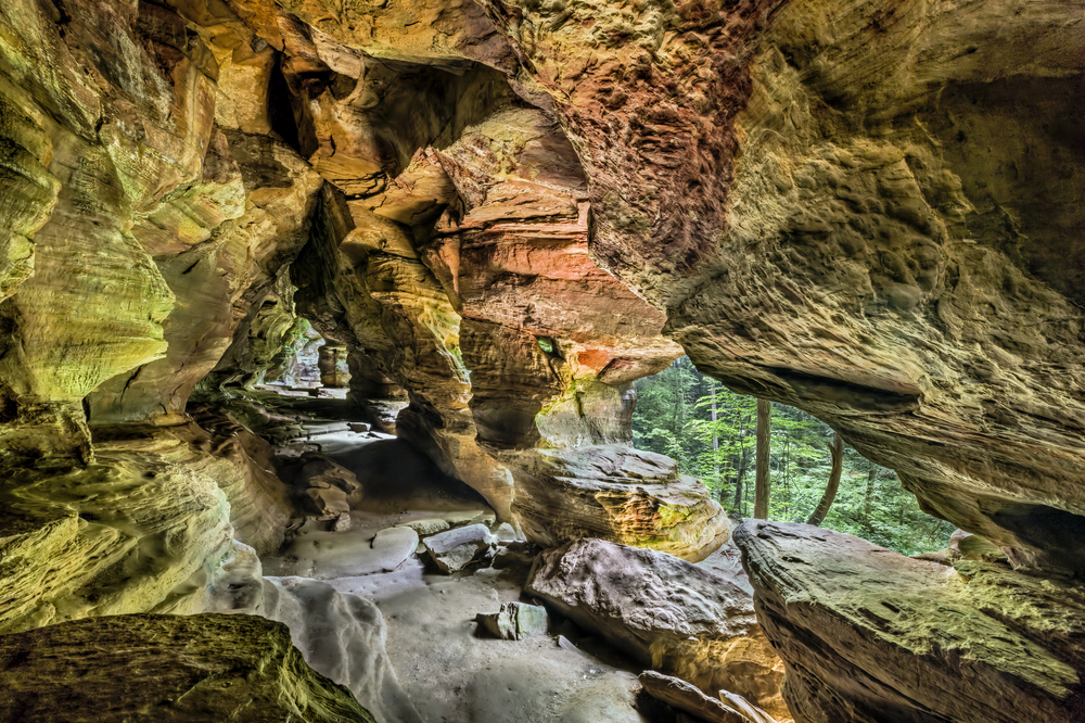 View inside of rocky cliffs, with holes looking out at the forest. while hiking in Ohio.