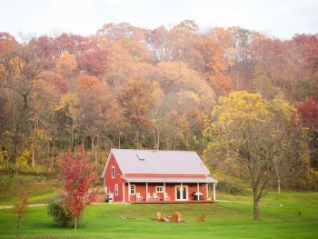 Red cabin surrounded by autumnal colored trees. Cabin in Wisconsin