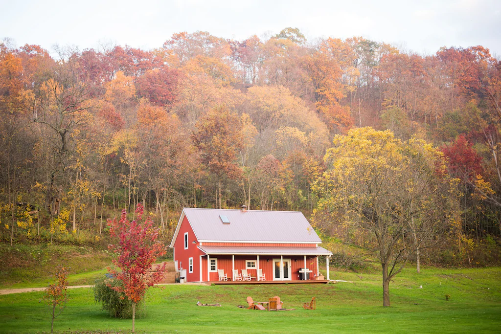 Red cabin surrounded by autumnal colored trees. Cabin in Wisconsin