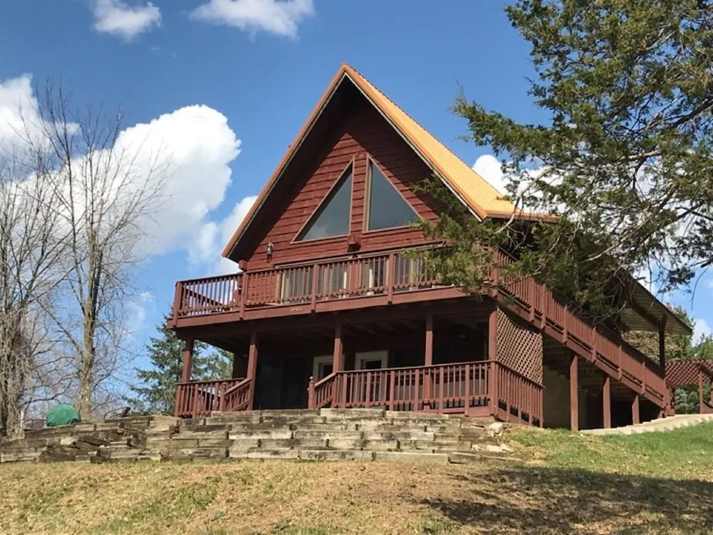 large log cabin with a blacony and deck and stone steps. One of the cabins in Wisconsin 