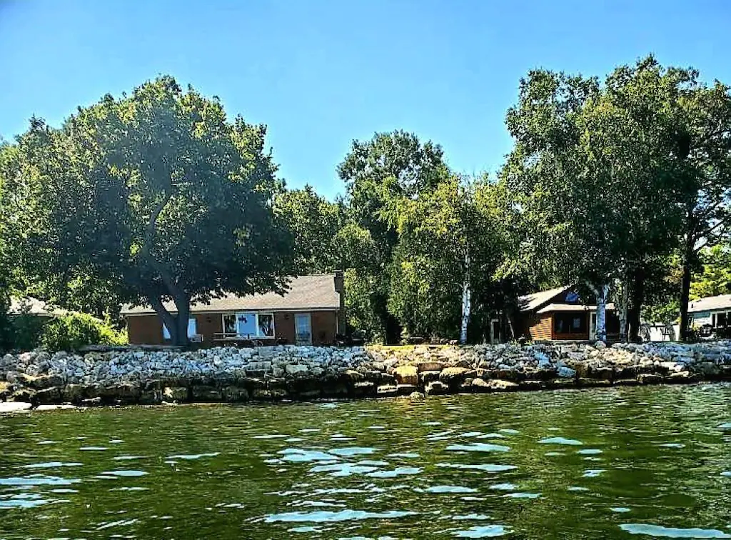 Two cabins by a rocky shoreline in an article about cabins in Wisconsin 