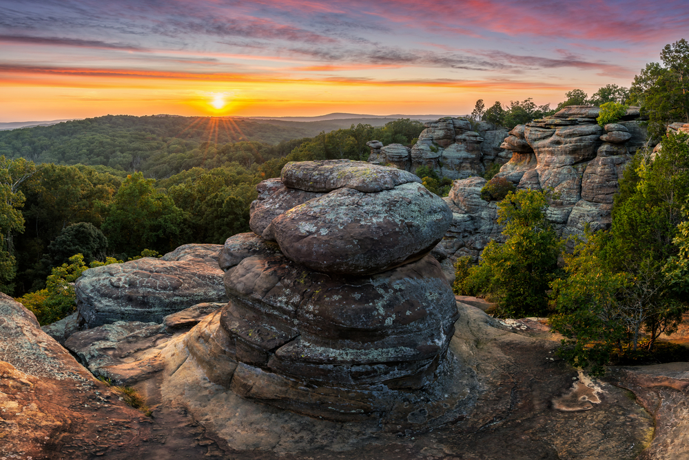 A view of the Garden of The Gods, a group of rock formations in Illinois. The sun is setting in the distance. It's one of the best places for hiking in Illinois. 
