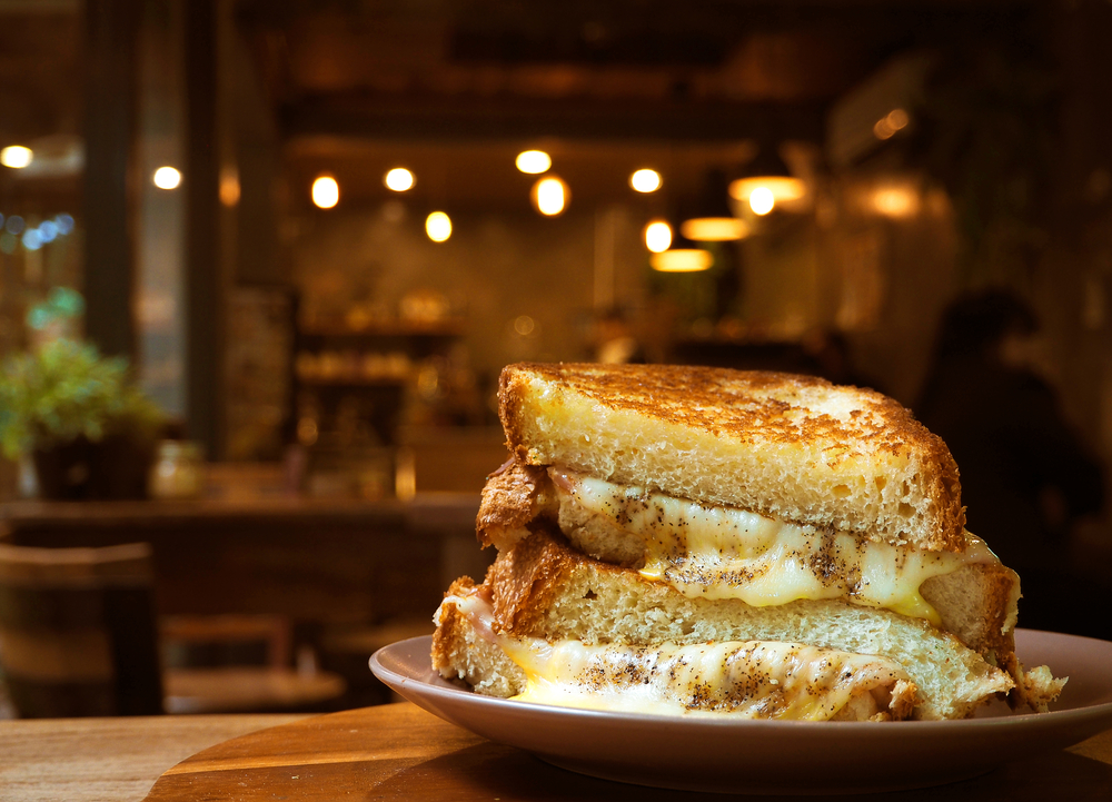 A closeup of a grilled cheese sandwich overflowing with cheese. Its similar to one you'd find in one of the best restaurants in Topeka. 