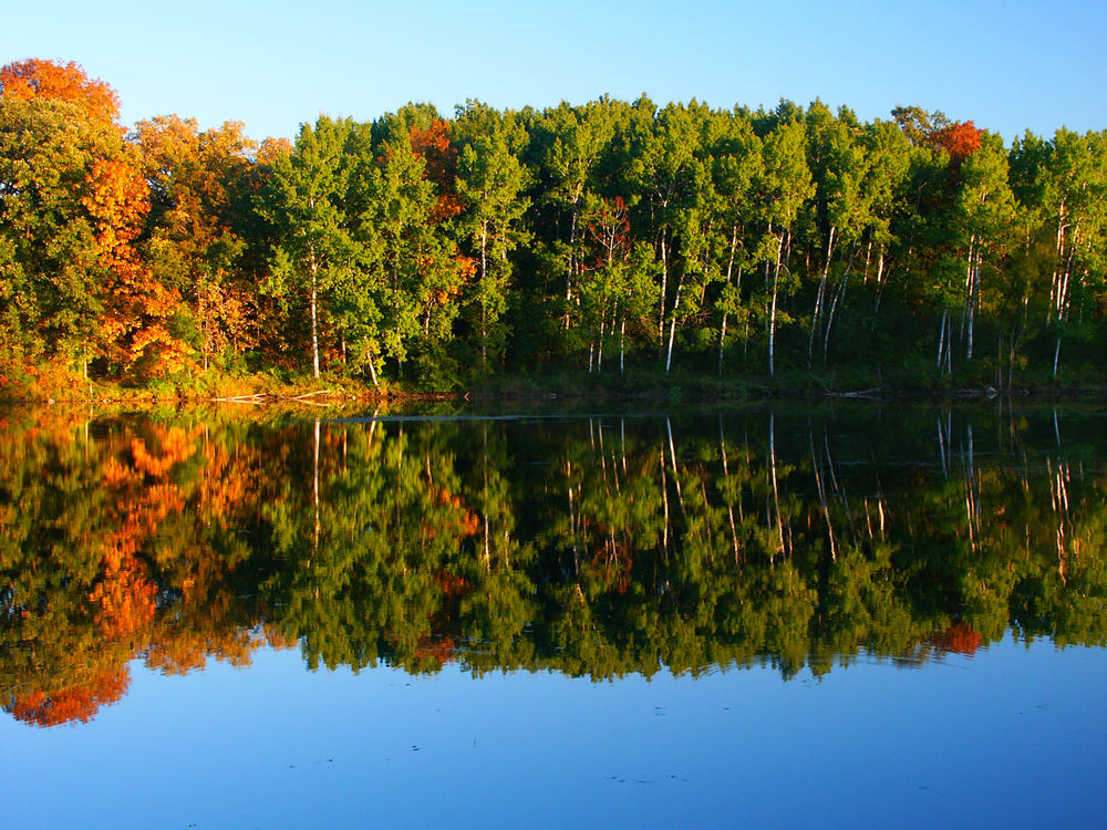 Fall foliage around a lake with reflection on water at a WI state park
