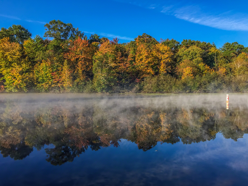 Fall foliage with fog perfectly mirrored in the lake at one of the best state parks in Wisconsin.