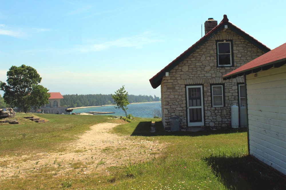 some old stone building on a lake and trees in the background at a state park in Wisconsin