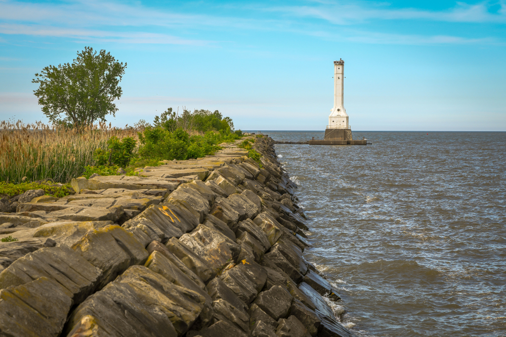lighthouse at the end of a pier with stone break wall in foreground. things to do in sandusky ohio