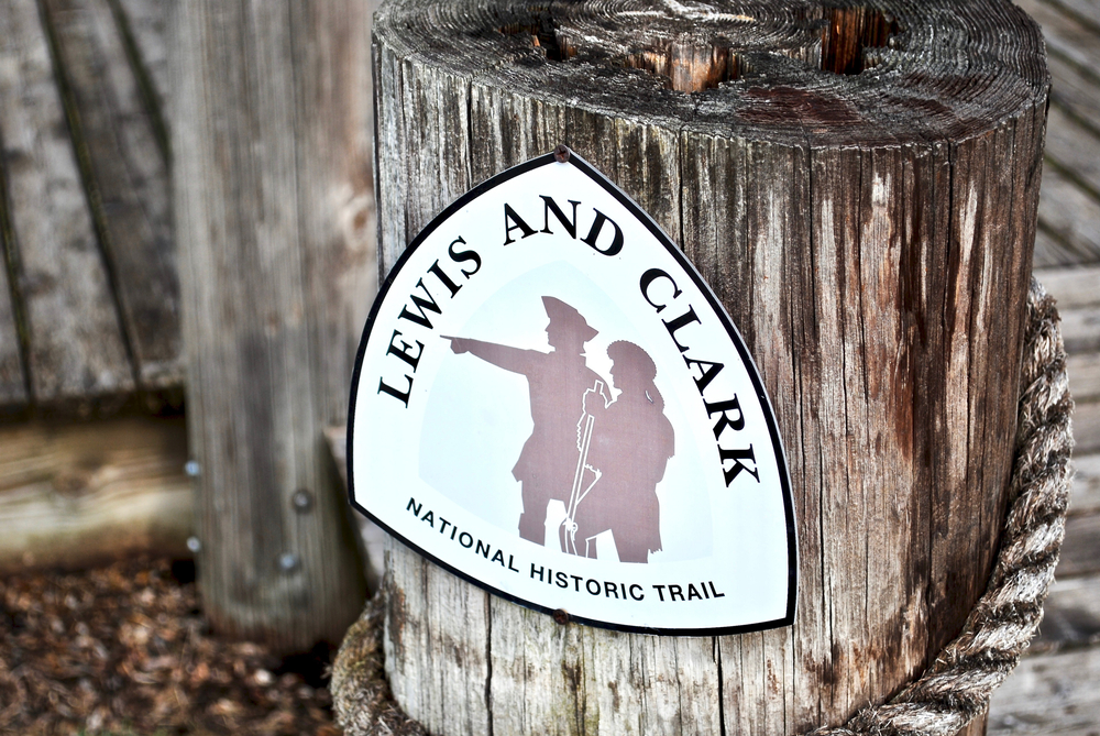 A wooden post with a sigh for the Lewis & Clark National Historic Trail showing a silhouette of the two men.