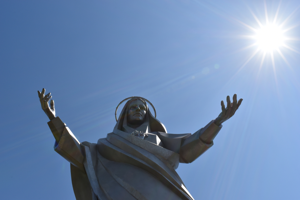 statue of mother mary with the sun behind 