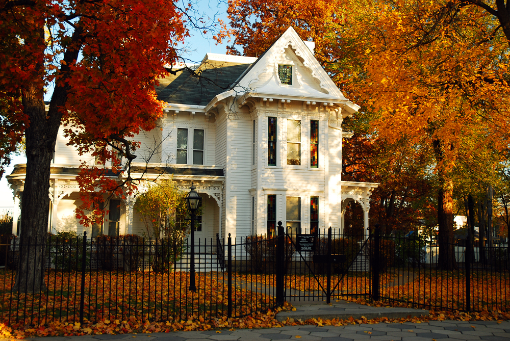White mansion with tall columns in front of it, surrounded by autumnal colored trees. Missouri national parks