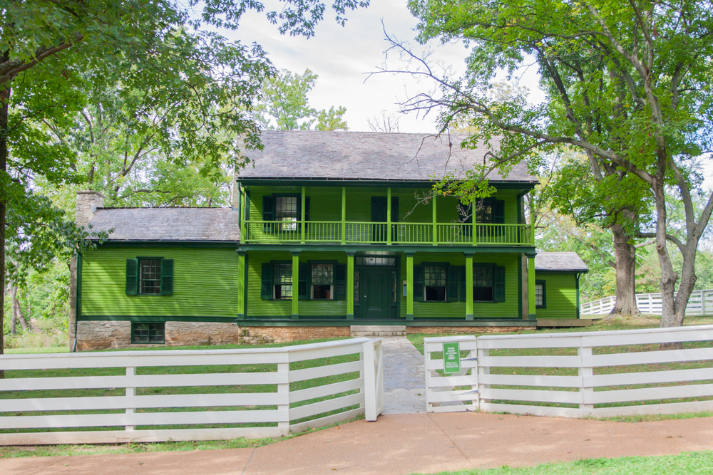 The green White Haven house behind a white fence.