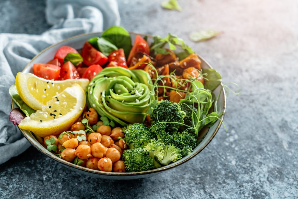 Salad bowl overflowing with green, red,  orange veggies and beans, with avocado rose as centerpiece. Best Lake Geneva restaurants.