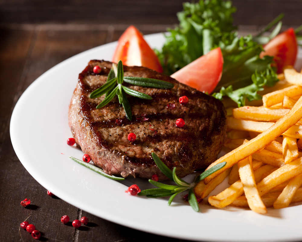 Peppercorn steak with fries and a side salad with red tomato wedges. restaurants in Oshkosh. 