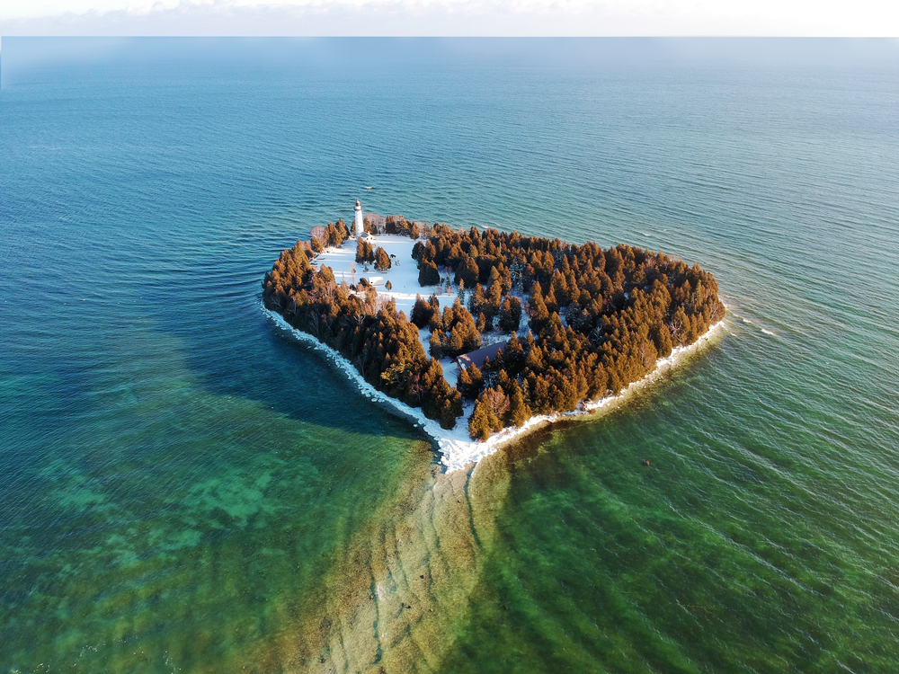 Heart shaped island covered in snow and trees in an article about romantic getaways in Wisconsin. 
