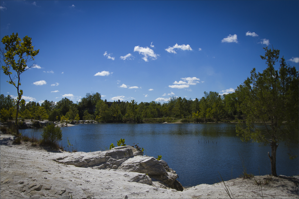 A lake in an old quarry surrounded by trees in an article about hikinng in Missouri 