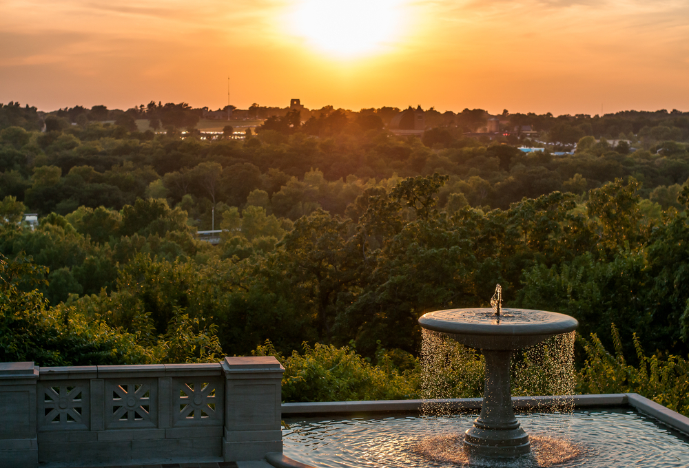 view of Swope park with a bird bath and an ornate wall. 