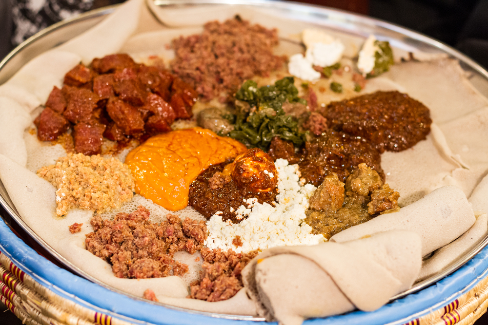 A variety of Ethiopian dishes on top of Ethiopian bread, similar to what you'd find at one of the best restaurants in Grand Rapids.