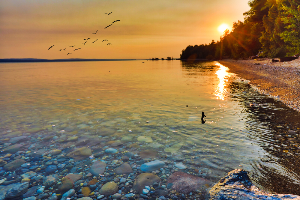 colorful pebbles in the water during sunset romantic getaways in michigan