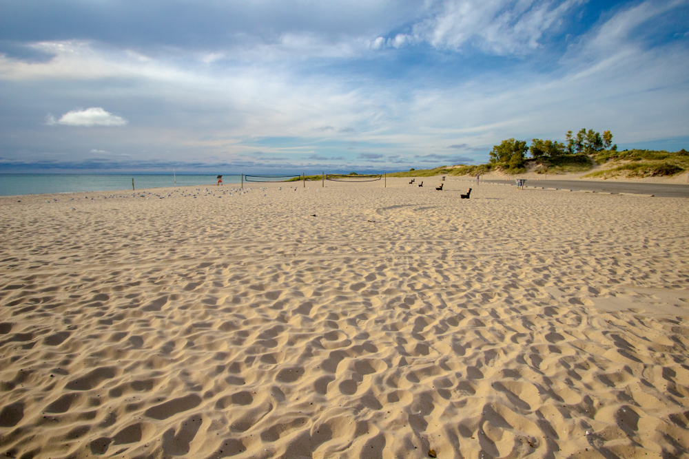 A sandy beach in Michigan on a sunny day, similar to one you can enjoy when you are looking for things to do in Grand Rapids. 