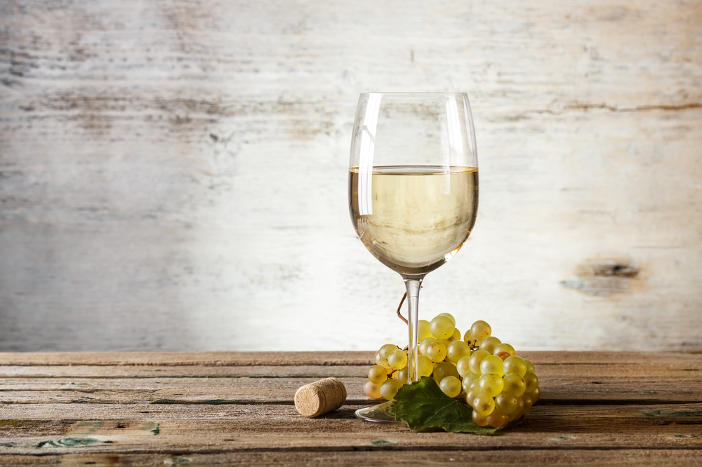 Glass of white wine on vintage wooden table