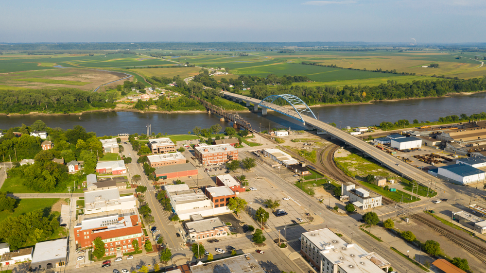 Aerial view of the town of Atchison, Kansas, featuring a bridge and the river.