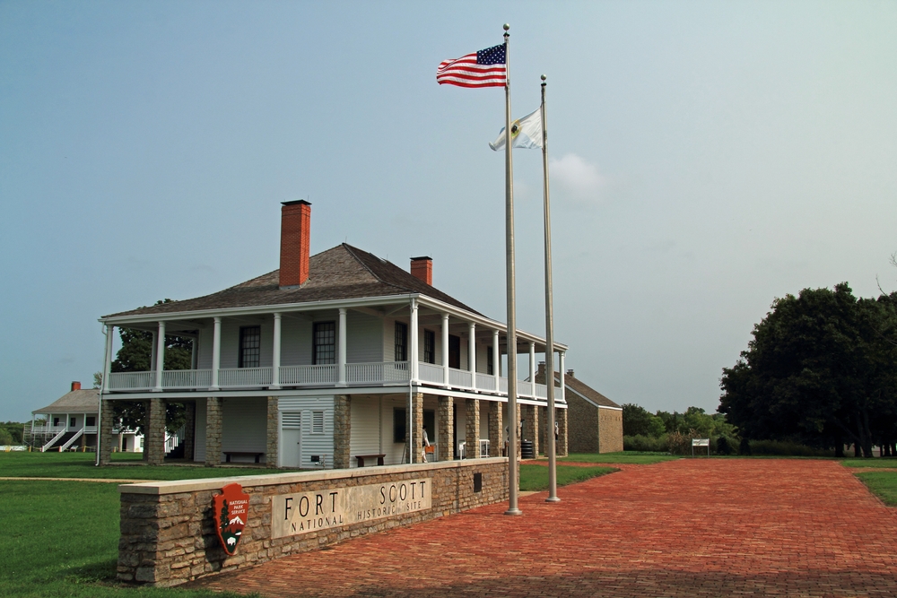 A building at Fort Scott with flags flying in front.