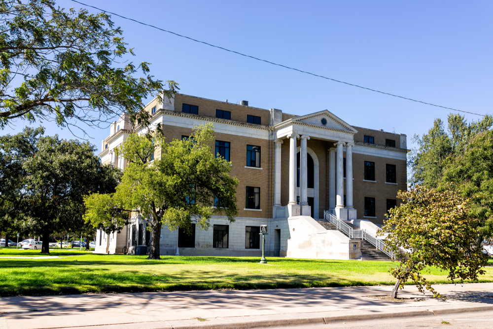 A historic courthouse next to trees in Larned, Kansas.