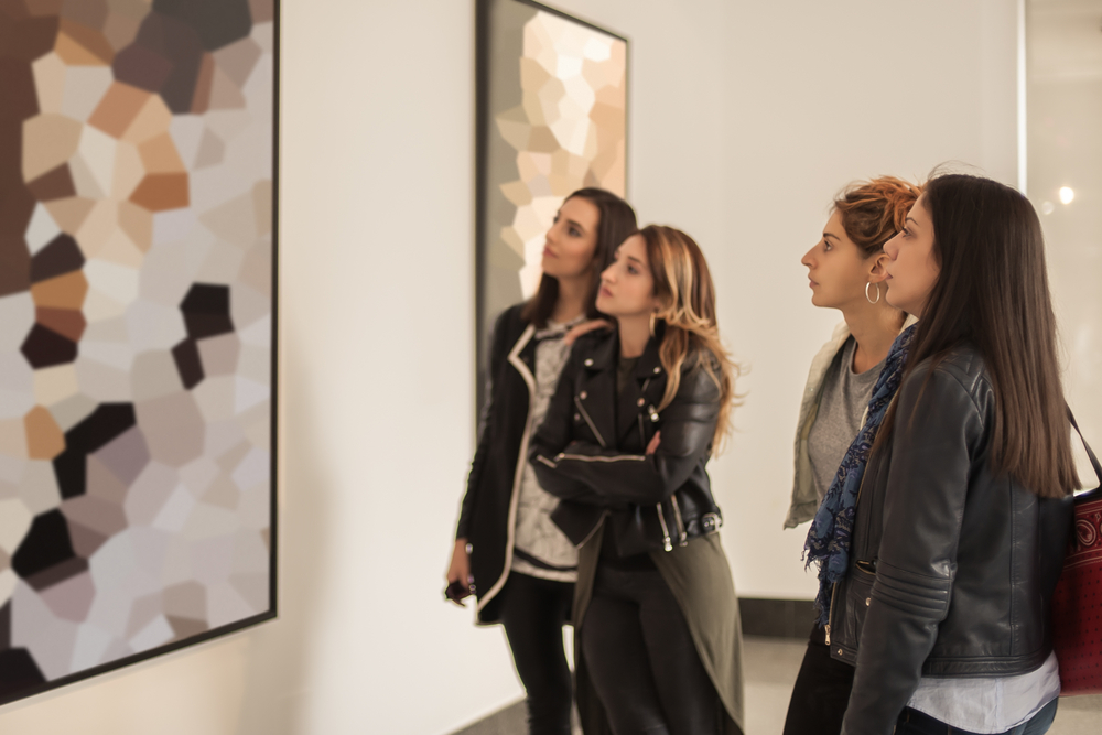 A group of women looking at a piece of modern art in an art museum, similar to one of the best things to do in Iowa City. 