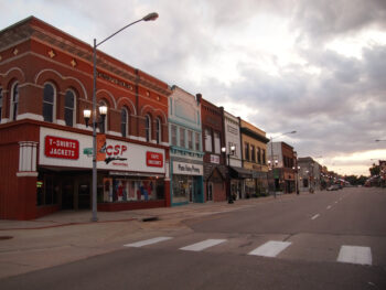 A main street in one of the historic towns in Nebraska where you can see old brick buildings, sidewalks, and streetlights.